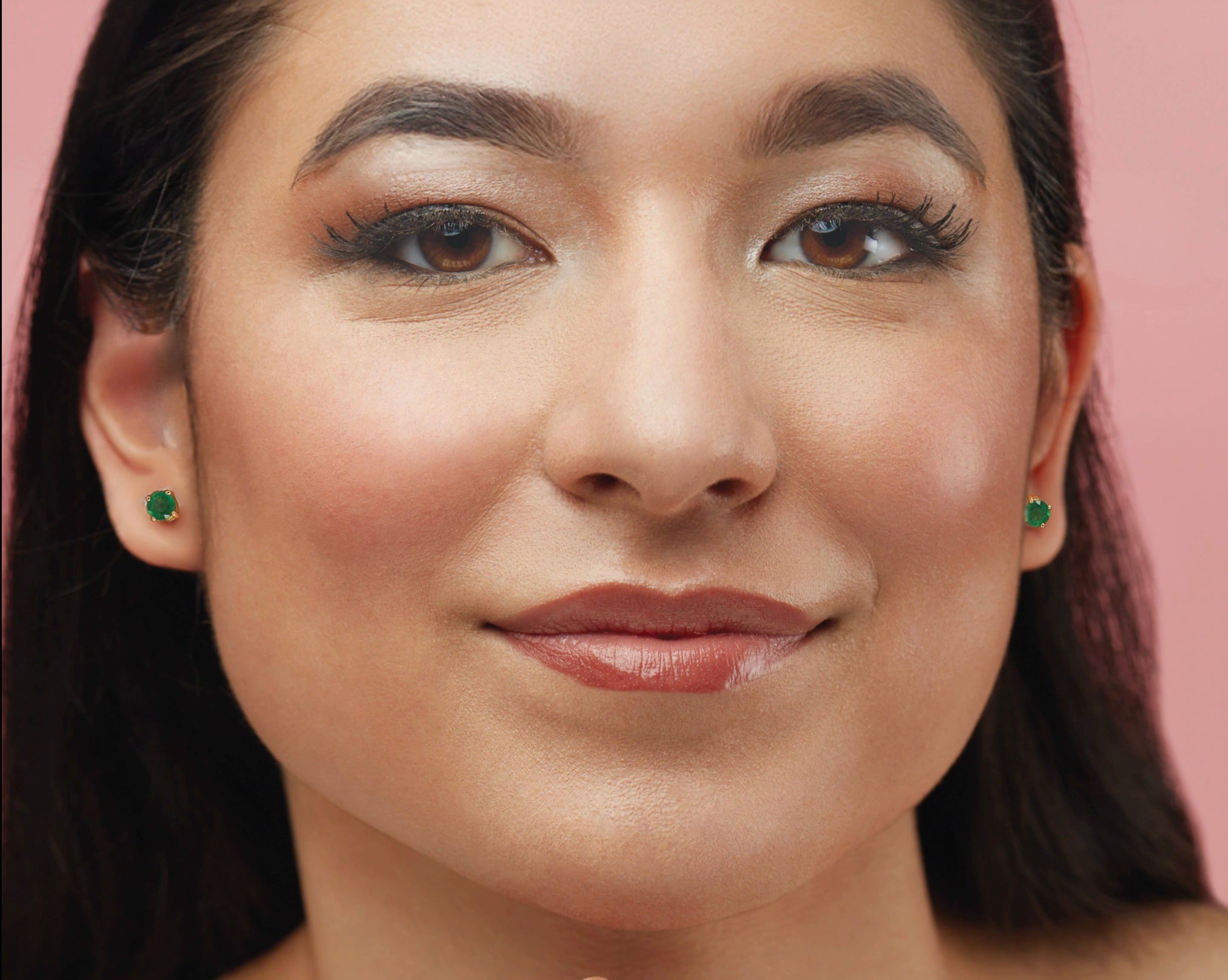 woman wearing green emerald studs 